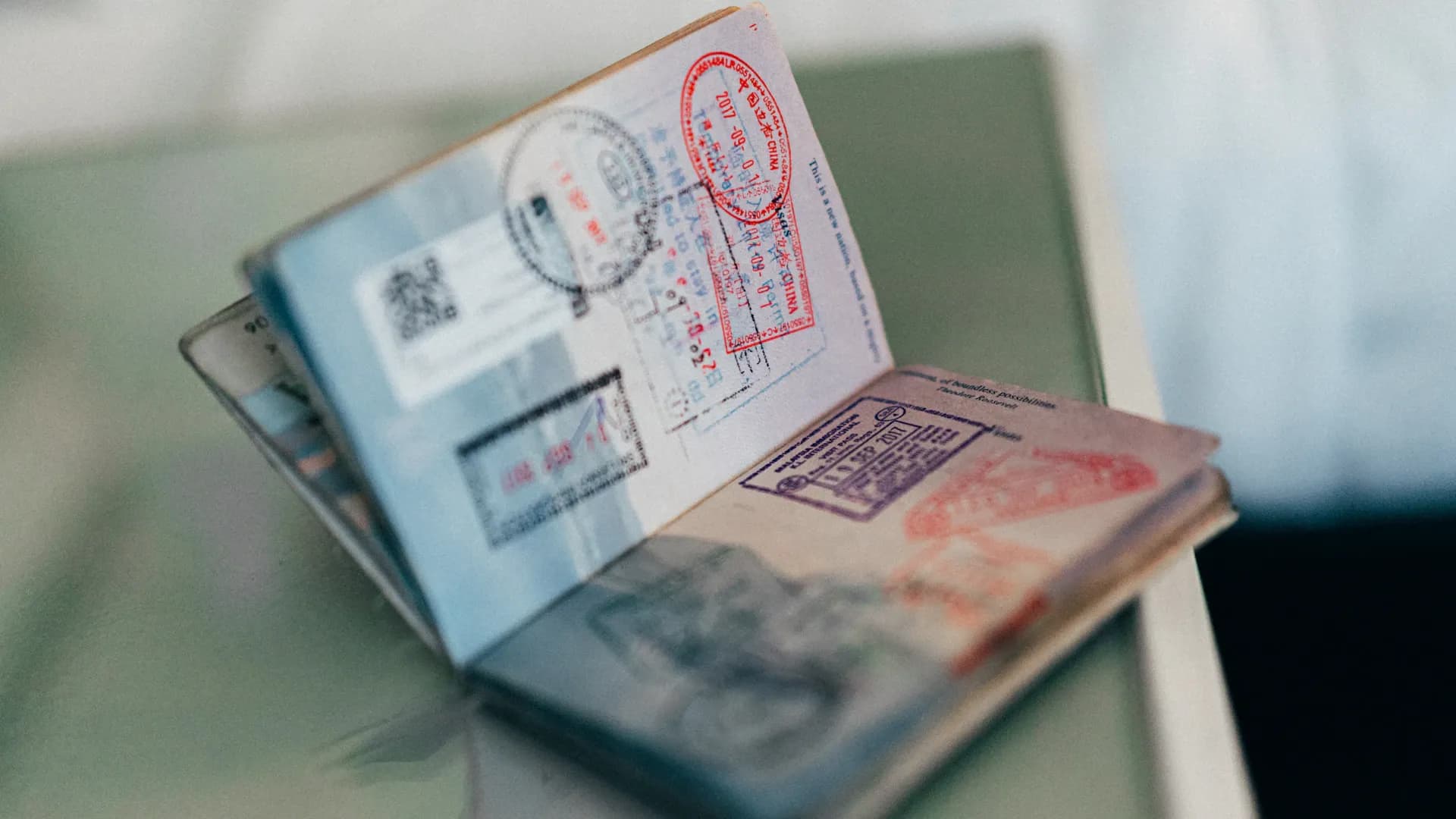 Un passeport ouvert avec plusieurs tampons d’encre colorés sur les pages