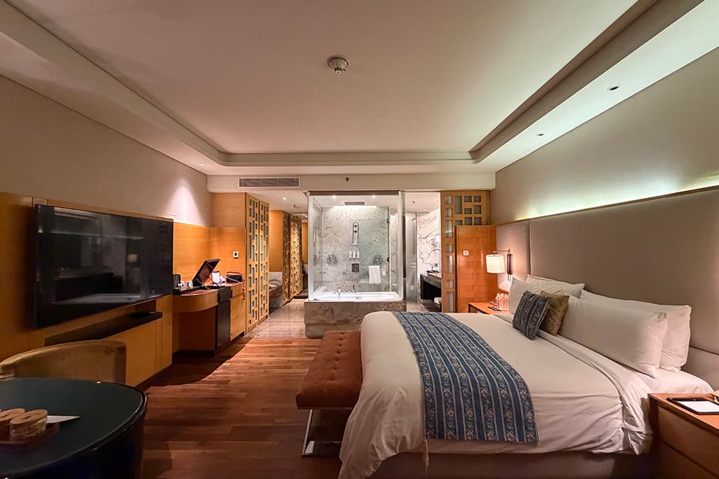 Vue d'ensemble de la chambre Executive Guest Room du JW Marriott Chandigarh, lit, télévision et salle de bain vitrée