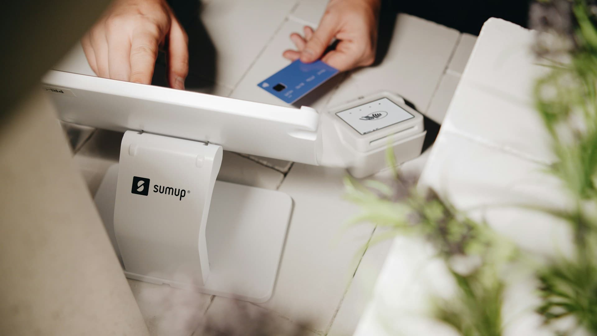 Une carte bancaire présentée devant un terminal de paiement