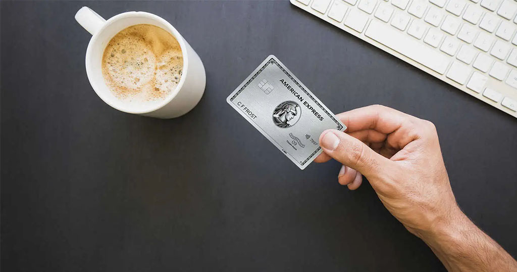 Tasse de café et une main tenant une carte American Express