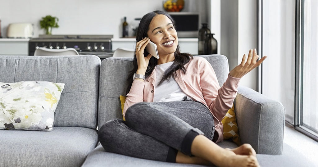 Femme sur son canapé discutant au téléphone