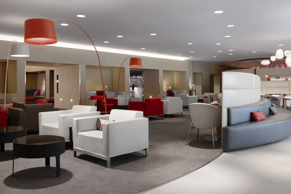 Salon La Première d'Air France avec fauteuils design rouges et blancs, ambiance élégante et feutrée.