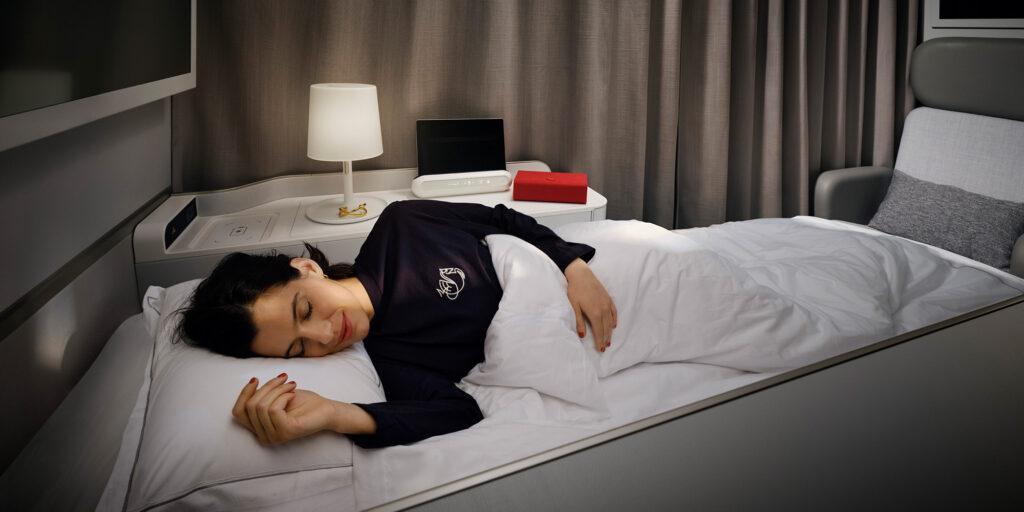 Femme dormant paisiblement dans un lit parfaitement dressé de la cabine La Première d'Air France.
