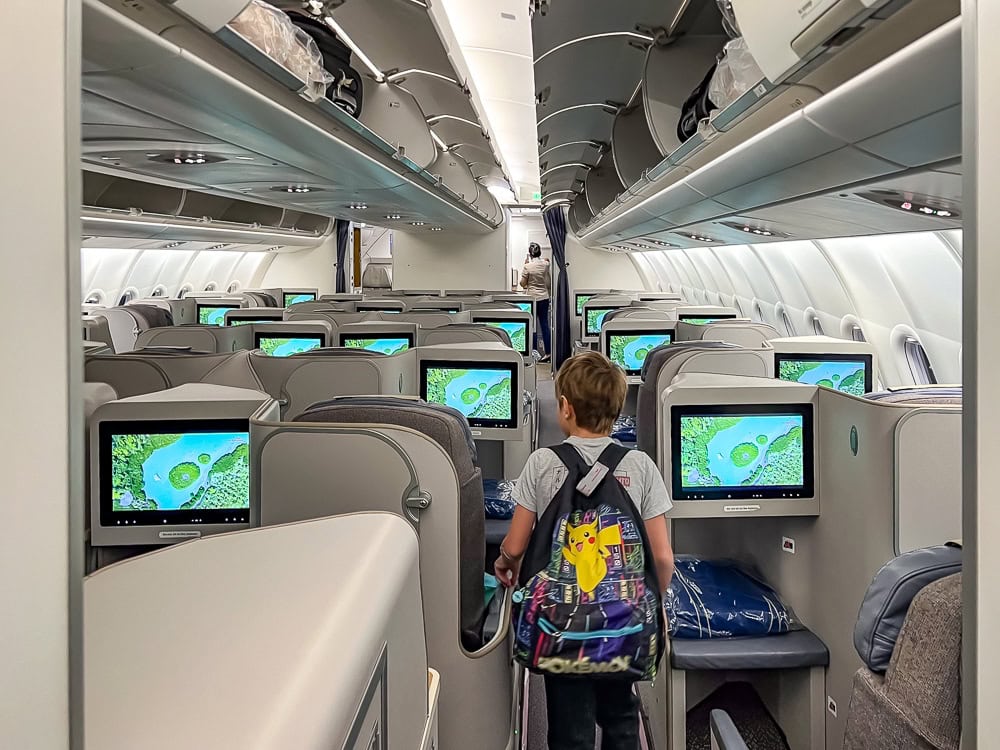 Intérieur d'un Airbus A330 d'Air Mauritius en classe affaires avec un enfant marchant dans l'allée.