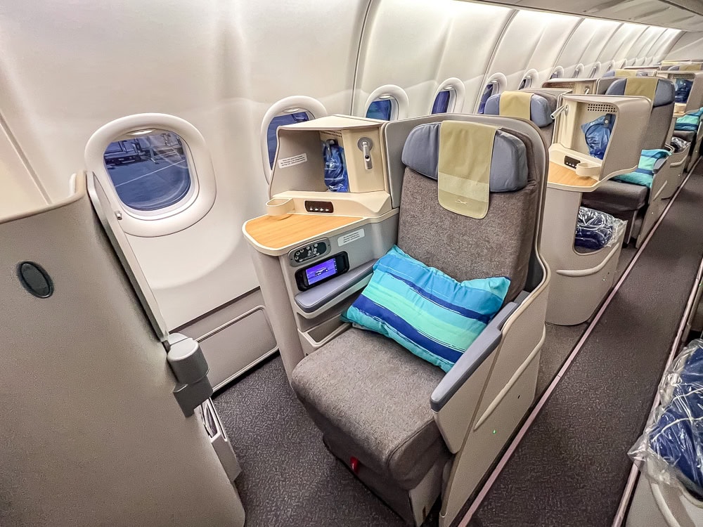 Siège en classe affaires Air Mauritius à bord d'un Airbus A330 avec oreiller rayé bleu.
