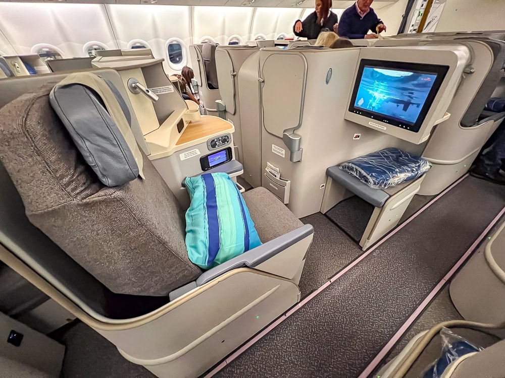 Siège en classe affaires Air Mauritius dans un Airbus A330 avec écran et oreiller turquoise.
