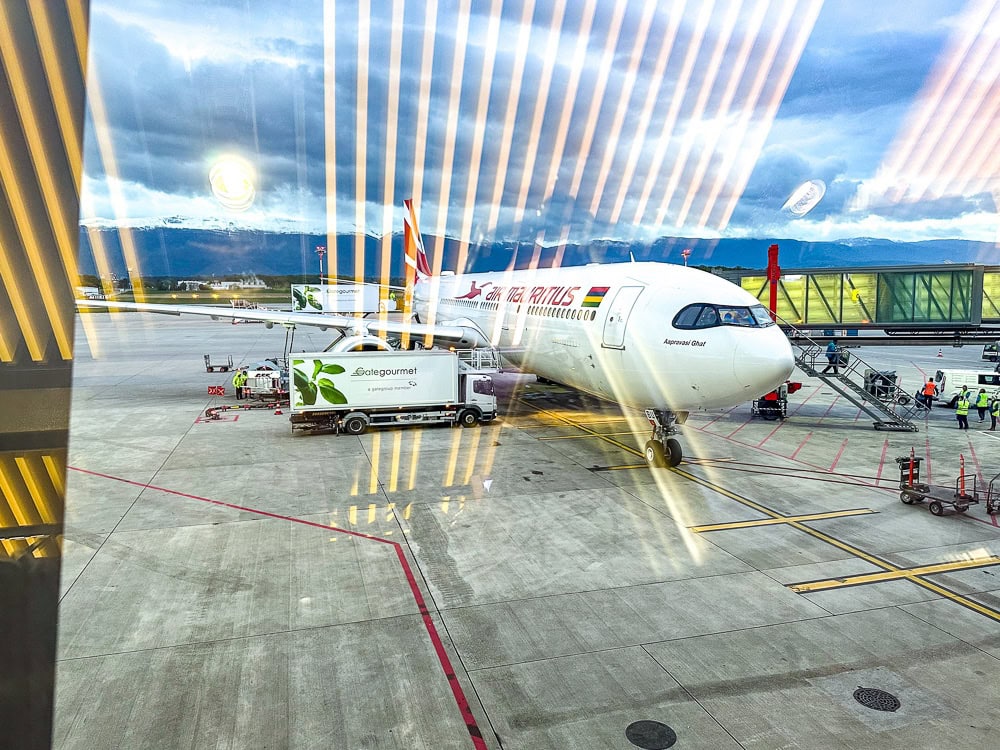 Avion Air Mauritius Airbus A330 stationné à la porte d'embarquement de l'aéroport sous un ciel nuageux.