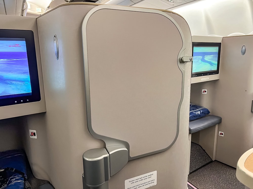 Sièges en classe Affaires à bord d'un Airbus A330 d'Air Mauritius avec écrans individuels allumés.