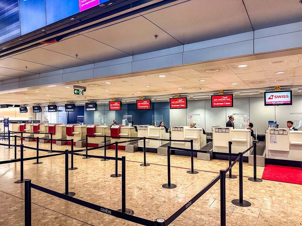 Comptoirs d'enregistrement Air Mauritius et SWISS à l'aéroport de Genève, avec files séparées par classe.