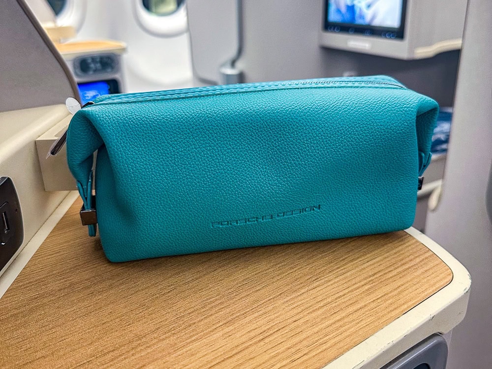 Trousse de voyage turquoise Air Mauritius posée sur une tablette en cabine affaires d'un Airbus A330.