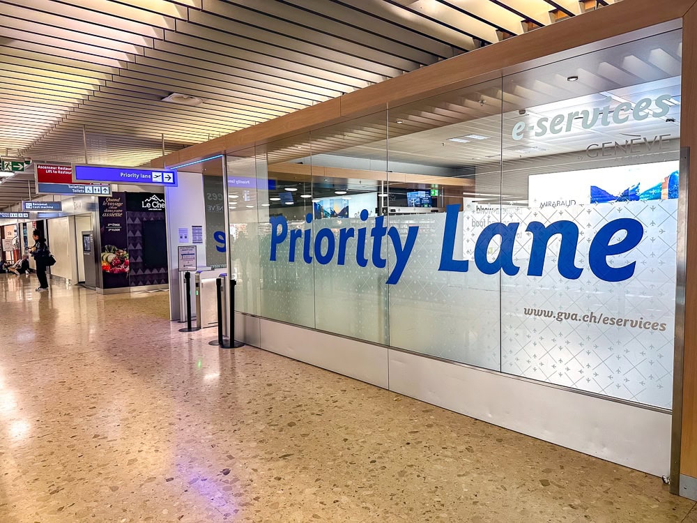 Couloir Priority Lane à l'aéroport de Genève avec signalétique bleue et accès prioritaire.