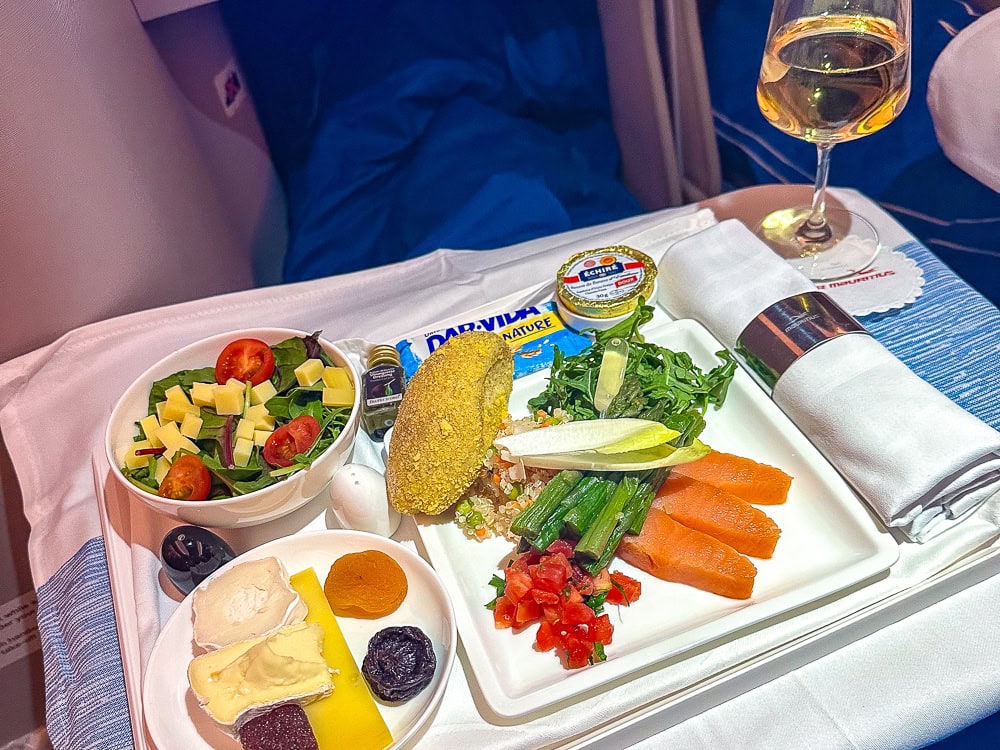 Plateau repas en classe affaires Air Mauritius sur Airbus A330neo avec saumon, salade et fromages.