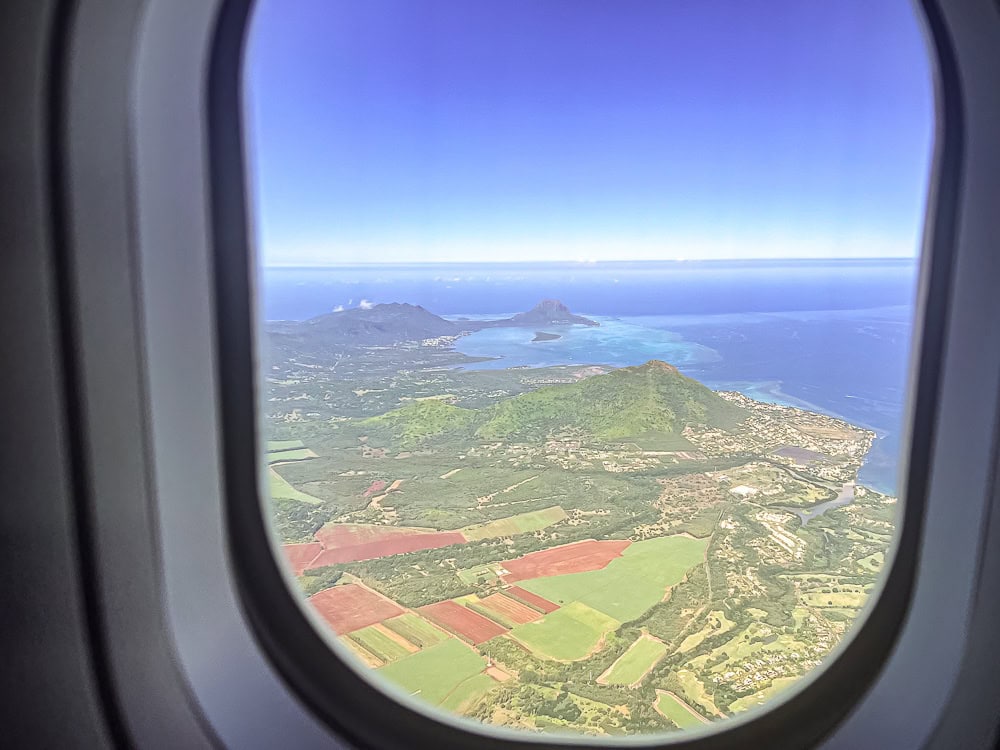 Vue aérienne de l'île Maurice depuis le hublot d'un avion Air Mauritius en plein vol.