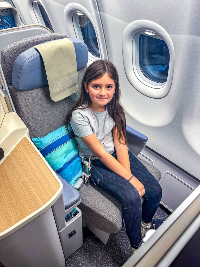 Jeune passagère assise dans un siège de classe affaires Air Mauritius à bord d'un Airbus A330neo.