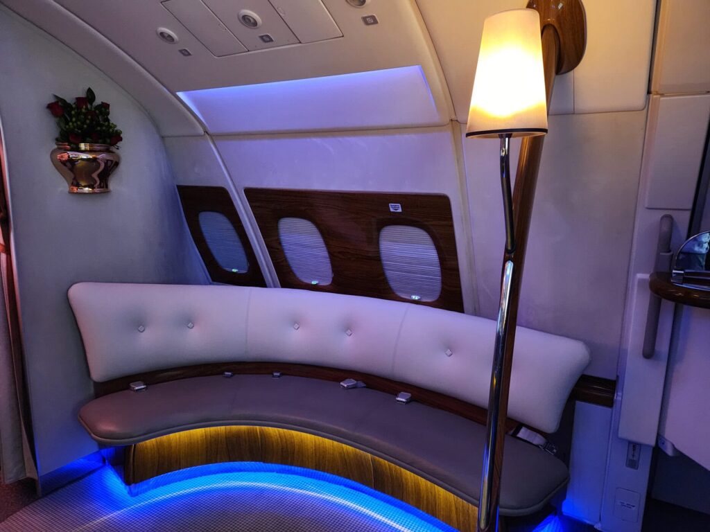 Salon lounge de l'Airbus A380 Emirates en classe Affaires avec éclairage d'ambiance bleu et assises en cuir