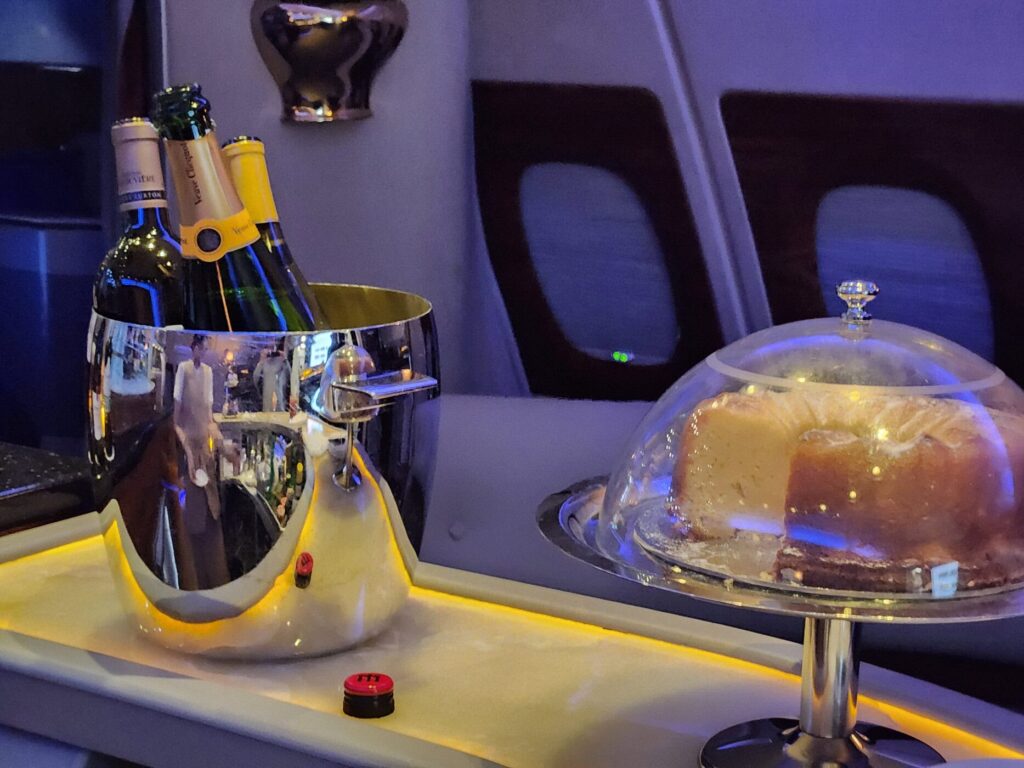 Seau à champagne Veuve Clicquot et gâteau sous cloche dans le bar à bord d'un Airbus A380 Emirates