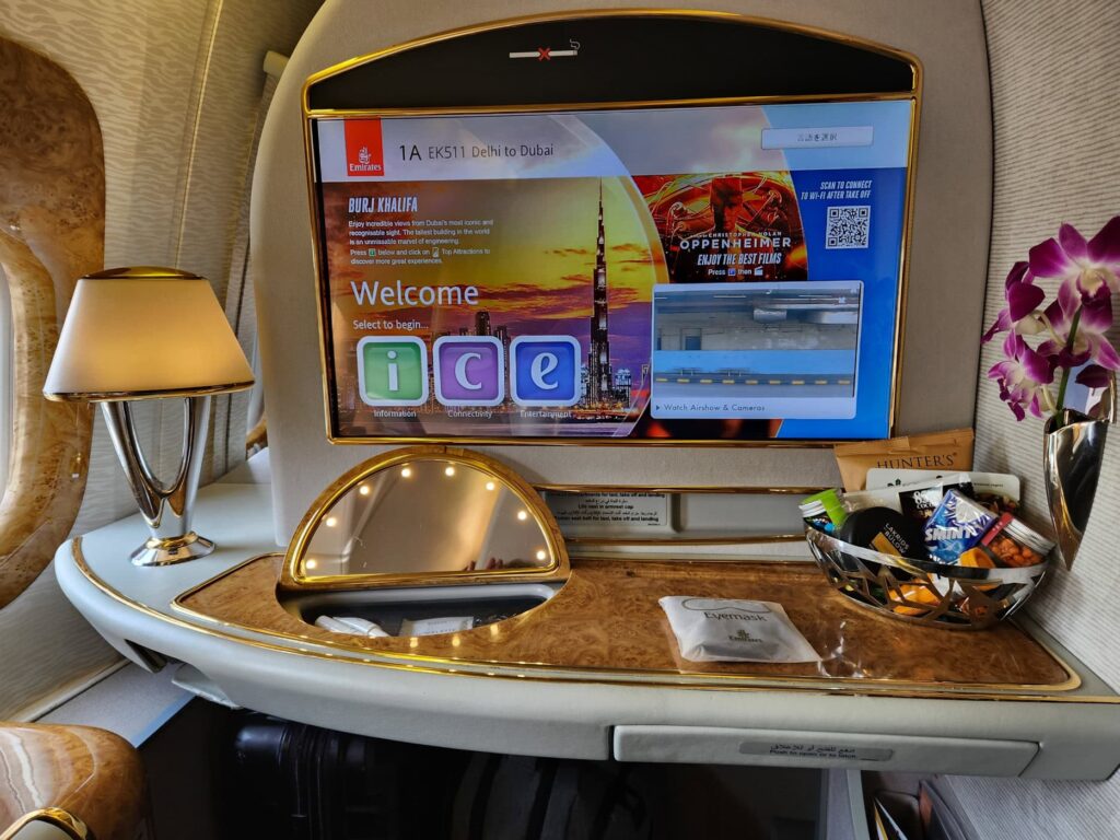 Suite de Première Classe Emirates avec écran ICE, lampe et produits de confort à bord.
