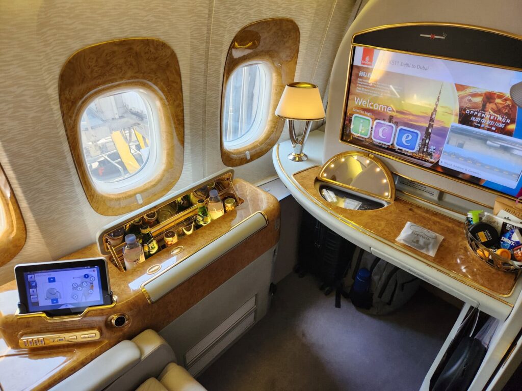 Siège de première classe Emirates avec écran ICE, mini-bar et tablette tactile à bord.
