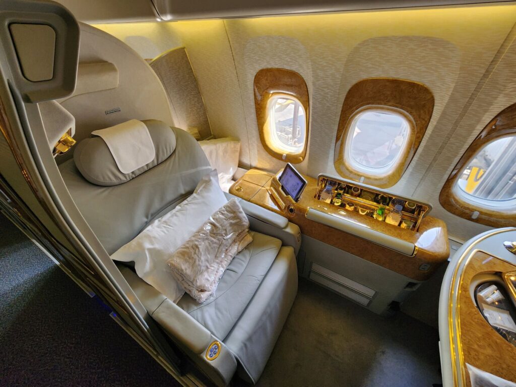 Suite de Première Classe Emirates sur Boeing 777 avec siège inclinable, mini-bar et tablette tactile