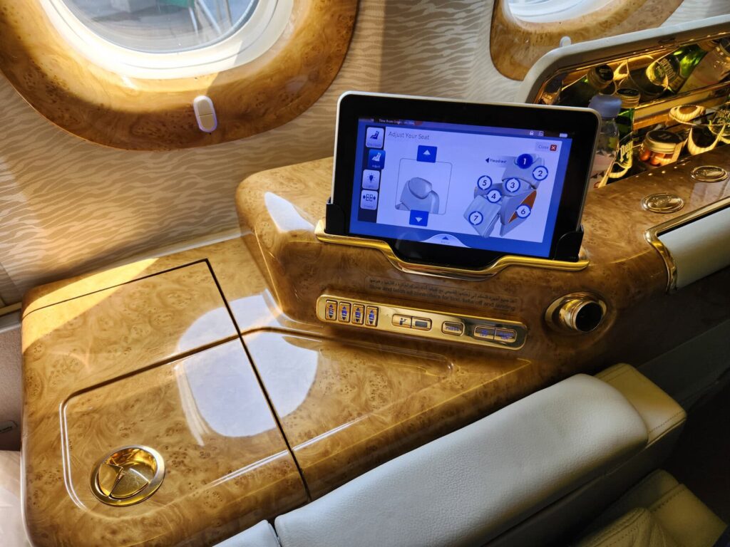 Siège de Première Classe Emirates avec tablette de contrôle et mini-bar intégré sous le hublot
