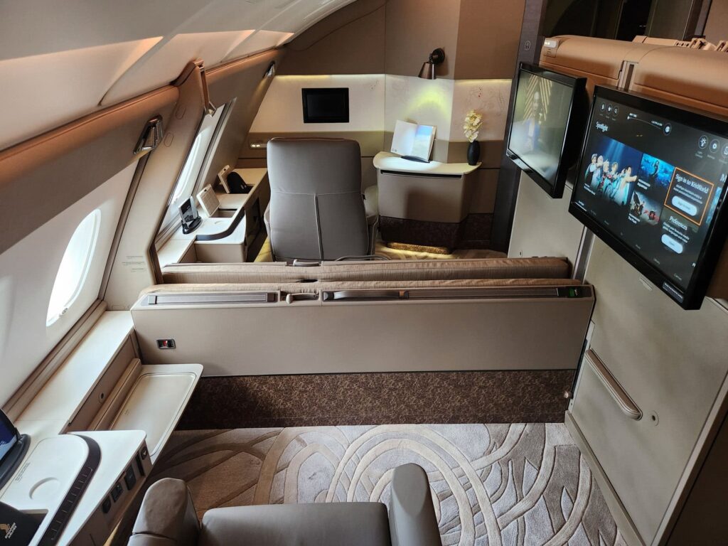 Suite de première classe Singapore Airlines avec siège inclinable, écran large et espace privé raffiné.