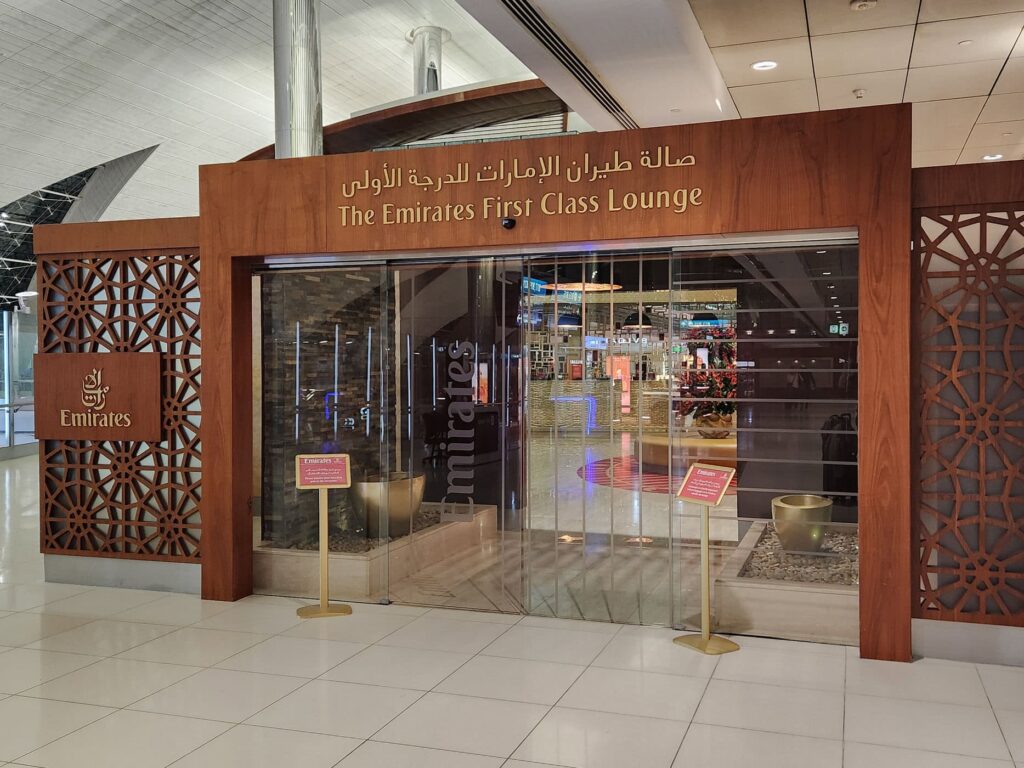 Entrée du Emirates First Class Lounge avec décor en bois et panneaux ajourés à l'aéroport de Dubaï.