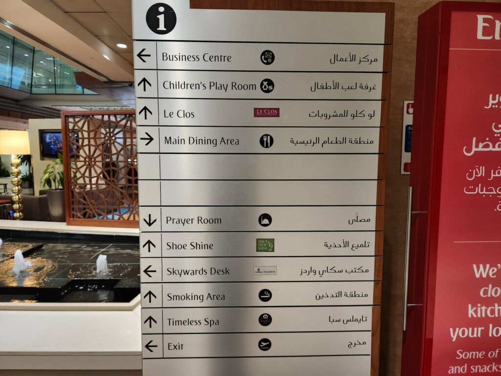 Panneau directionnel dans le lounge Emirates avec indications vers spa, salle de prière et restaurant.