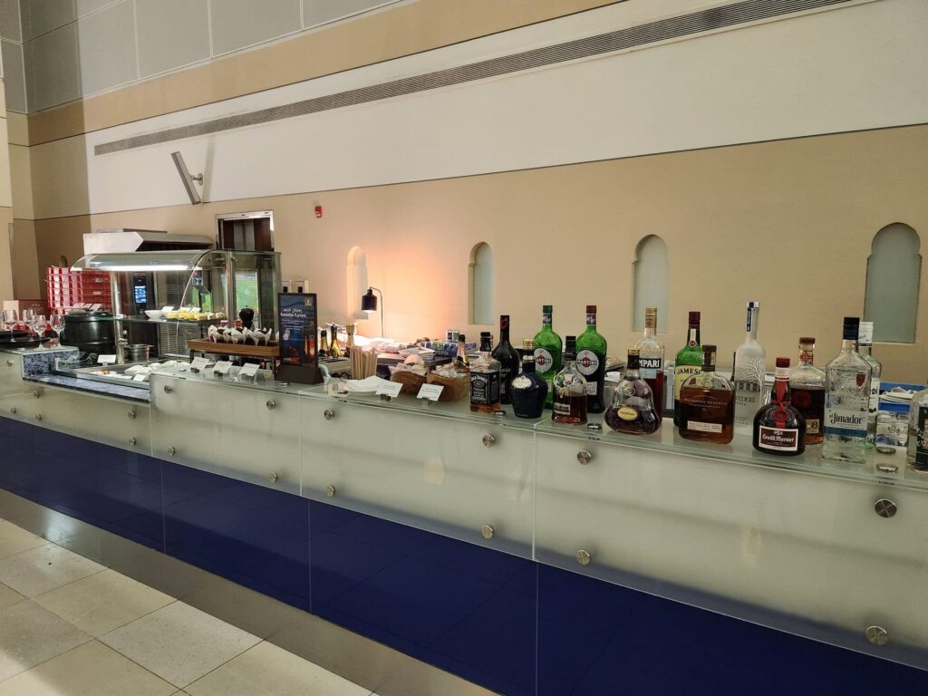 Comptoir de bar avec alcools et plats froids au salon Emirates à l'aéroport de Dubaï.