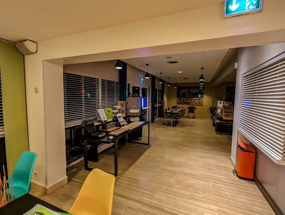 Espace de restauration lumineux de l'hôtel Ibis Styles Ouistreham avec tables modernes et chaises colorées