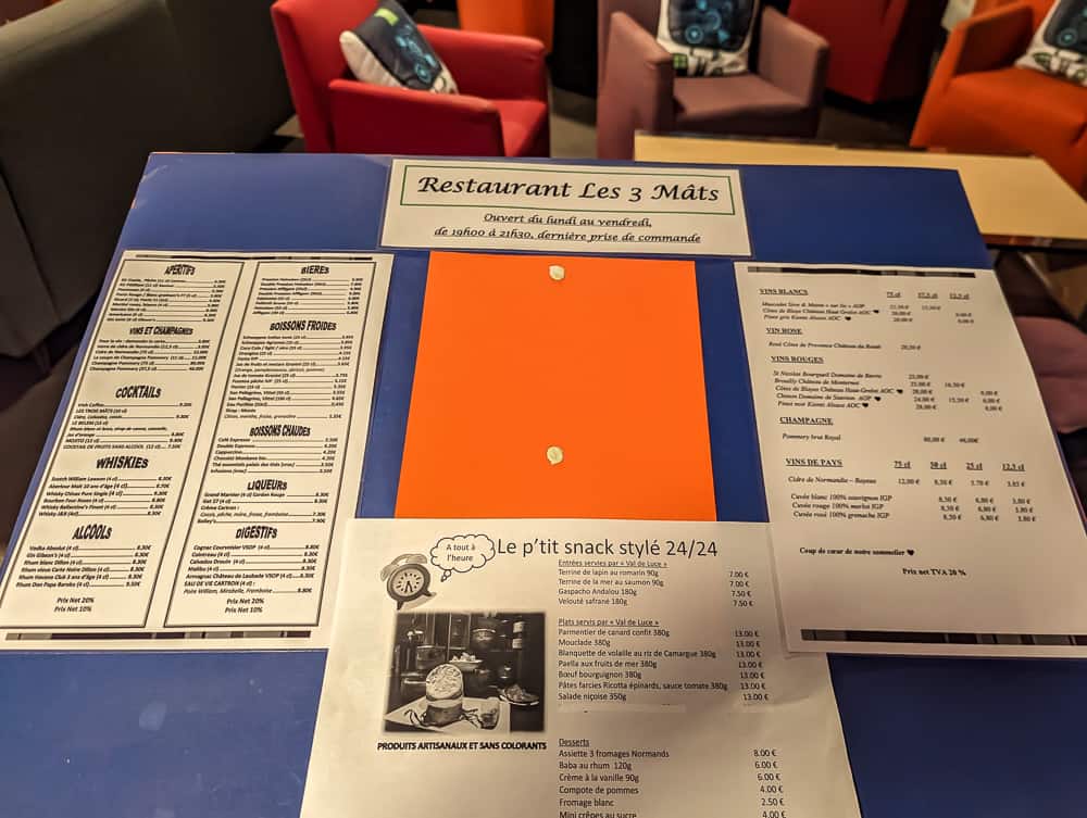 Présentation du menu du restaurant Les 3 Mâts à l'Ibis Styles Ouistreham avec fauteuils colorés en arrière-plan