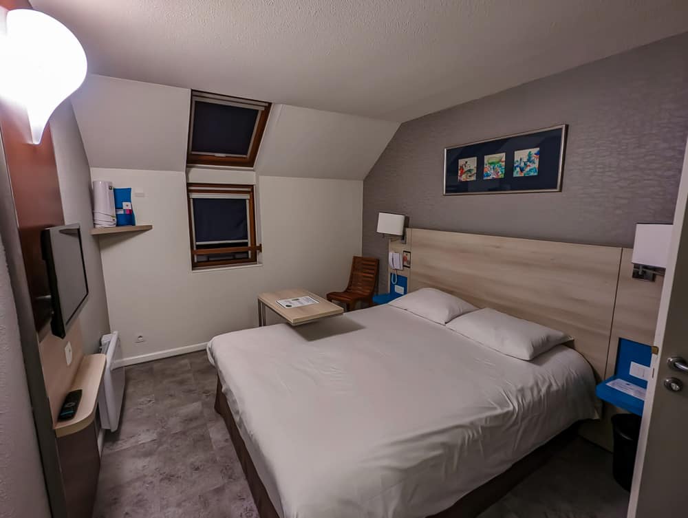 Chambre double compacte à l'Ibis Styles Ouistreham avec lit queen, deux lucarnes et décoration sobre