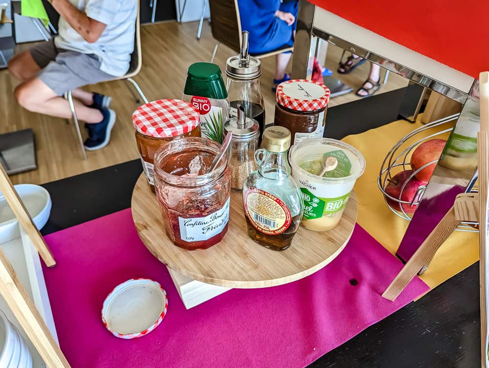 Pots de confiture, miel et compote bio disposés sur un plateau au petit-déjeuner de l'Ibis Styles Ouistreham