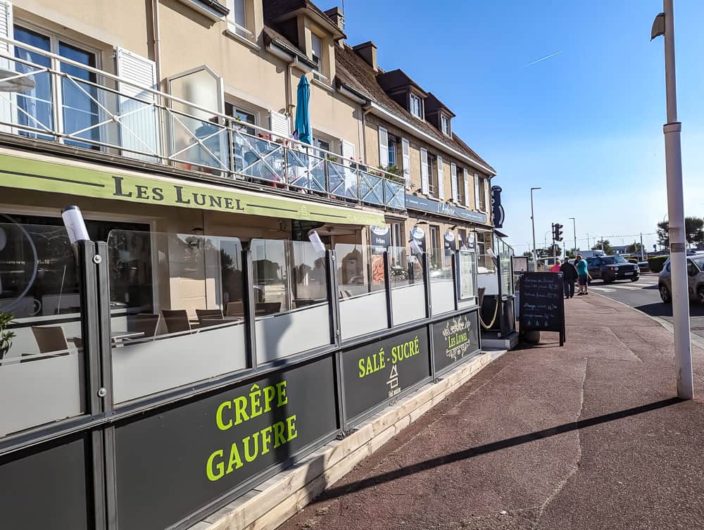 Façade de l'hôtel Ibis Styles Ouistreham avec terrasse vitrée du restaurant sous un ciel bleu