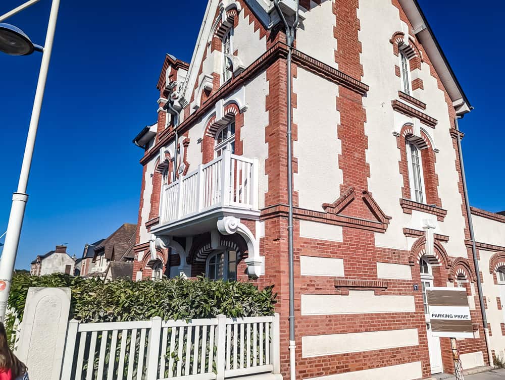 Façade en briques rouges et blanches de l'hôtel Ibis Styles Ouistreham sous un ciel bleu clair