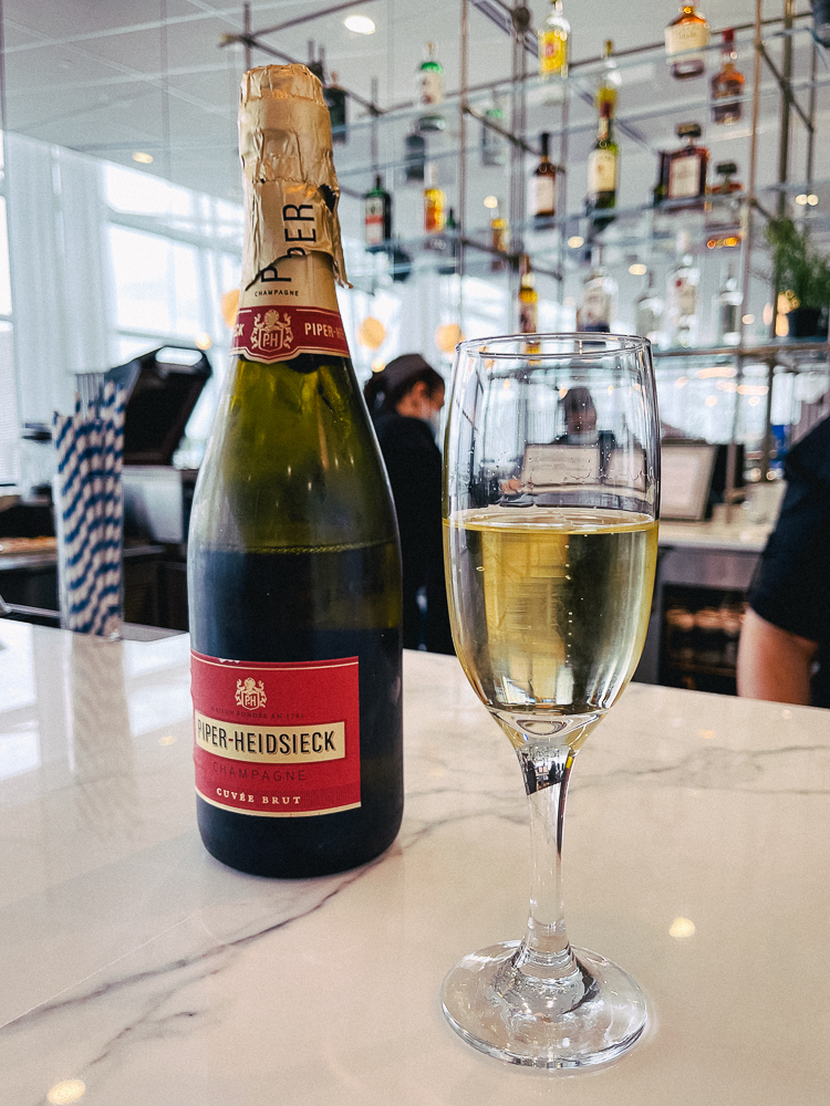 Bouteille de champagne Piper-Heidsieck et flûte servie au bar du salon Air France Montréal.