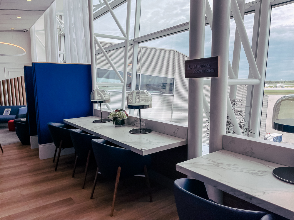 Espace de coworking lumineux au salon Air France de Montréal avec vue sur le tarmac.