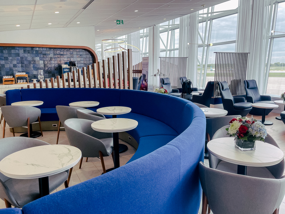 Espace détente élégant du salon Air France à Montréal avec sièges bleus et tables en marbre.