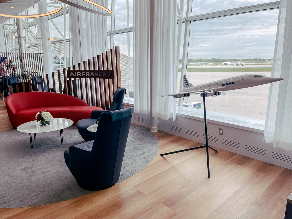 Salon Air France à Montréal avec maquette d'avion et espace détente moderne avec canapés design.