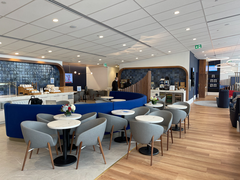 Salon Air France de Montréal YUL avec sièges gris, banquettes bleues et espace de restauration moderne.