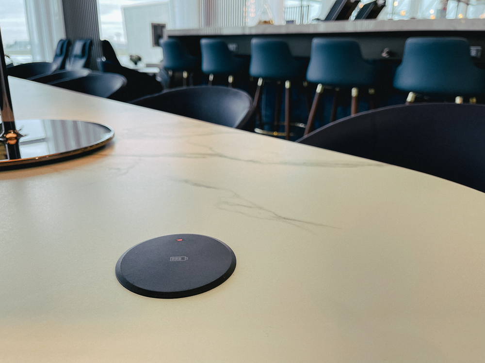 Zone de recharge sans fil sur une table du salon Air France à Montréal YUL.