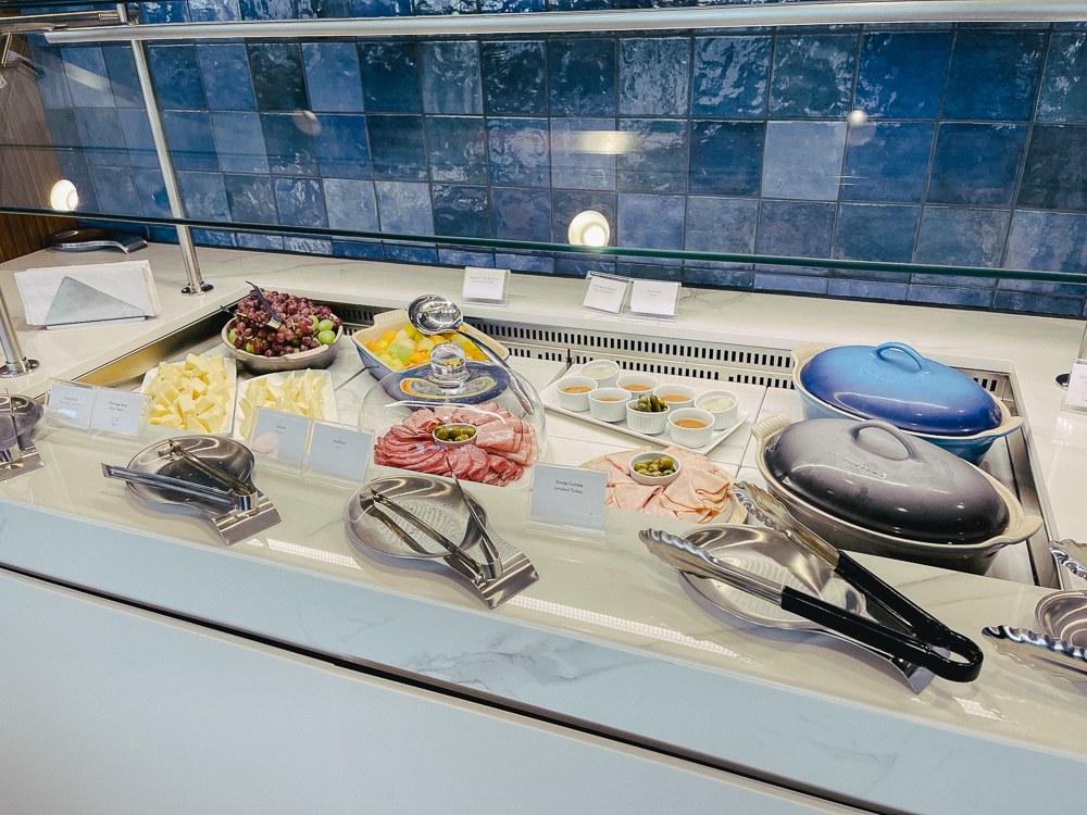 Comptoir de buffet froid avec fromages, charcuteries, fruits et condiments au salon Air France Montréal.