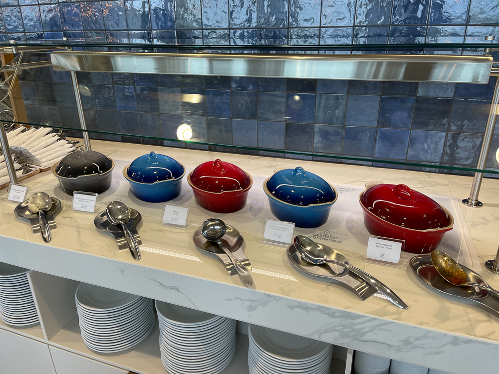 Buffet chaud du salon Air France à Montréal avec casseroles colorées et ustensiles de service.