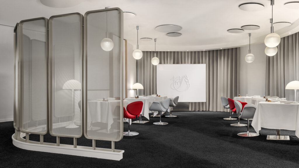 Salle à manger du salon La Première Air France avec fauteuils Ribbon gris et rouges à Paris-CDG