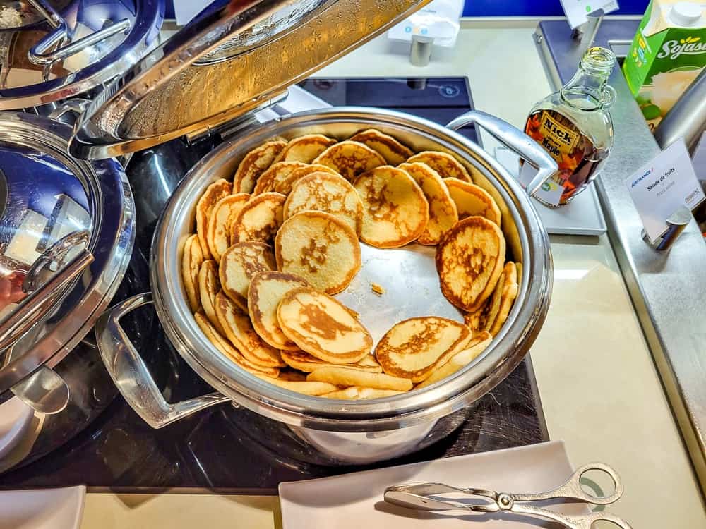 Plat chaud en inox rempli de pancakes, sirop d'érable et brique de lait de soja