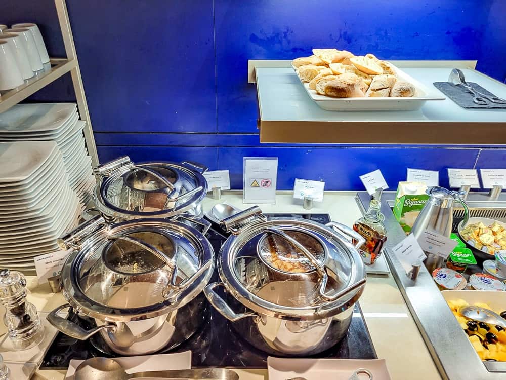 Chafing dishes en inox et corbeille de pains au buffet chaud du salon
