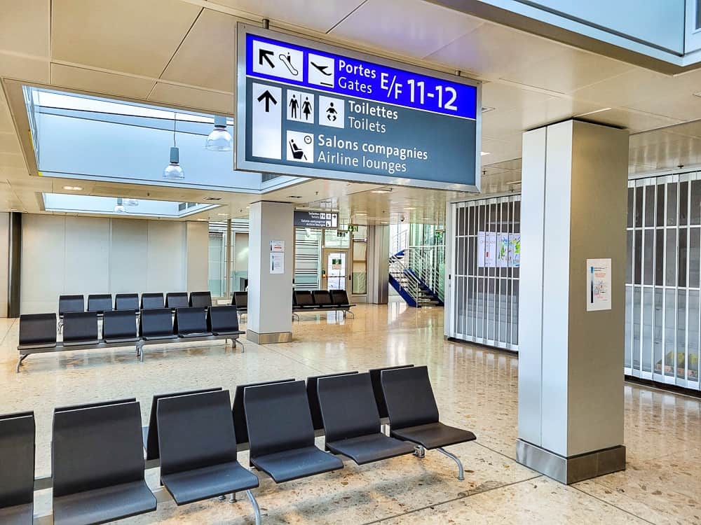 Couloir de l'aéroport de Genève avec panneau portes E/F 11-12 et salons compagnies