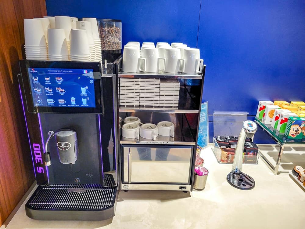 Machine à café automatique du salon, gobelets et tasses blanches empilés au-dessus
