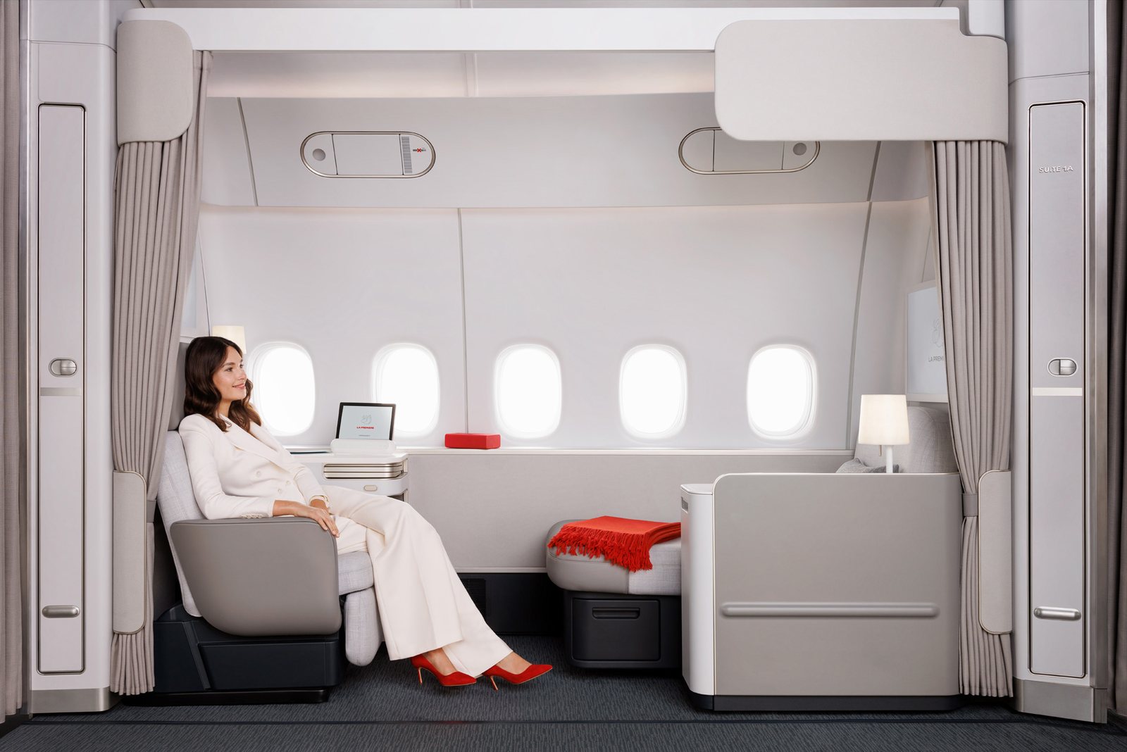 Passagère installée dans la nouvelle suite La Première d'Air France le long de cinq hublots